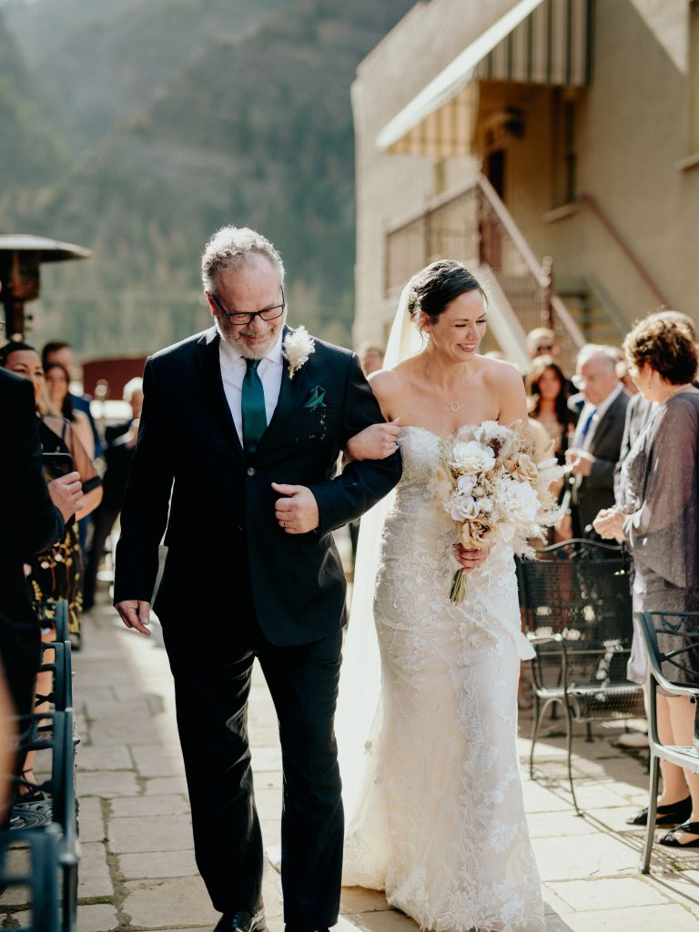 father walks daughter down the aisle into the Ouray, Colorado wedding venue