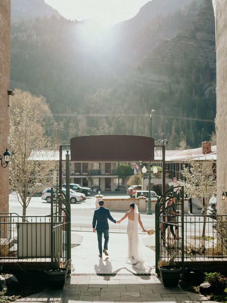 beautiful bride and groom pose in Ouray, Colorado outside the wedding venue