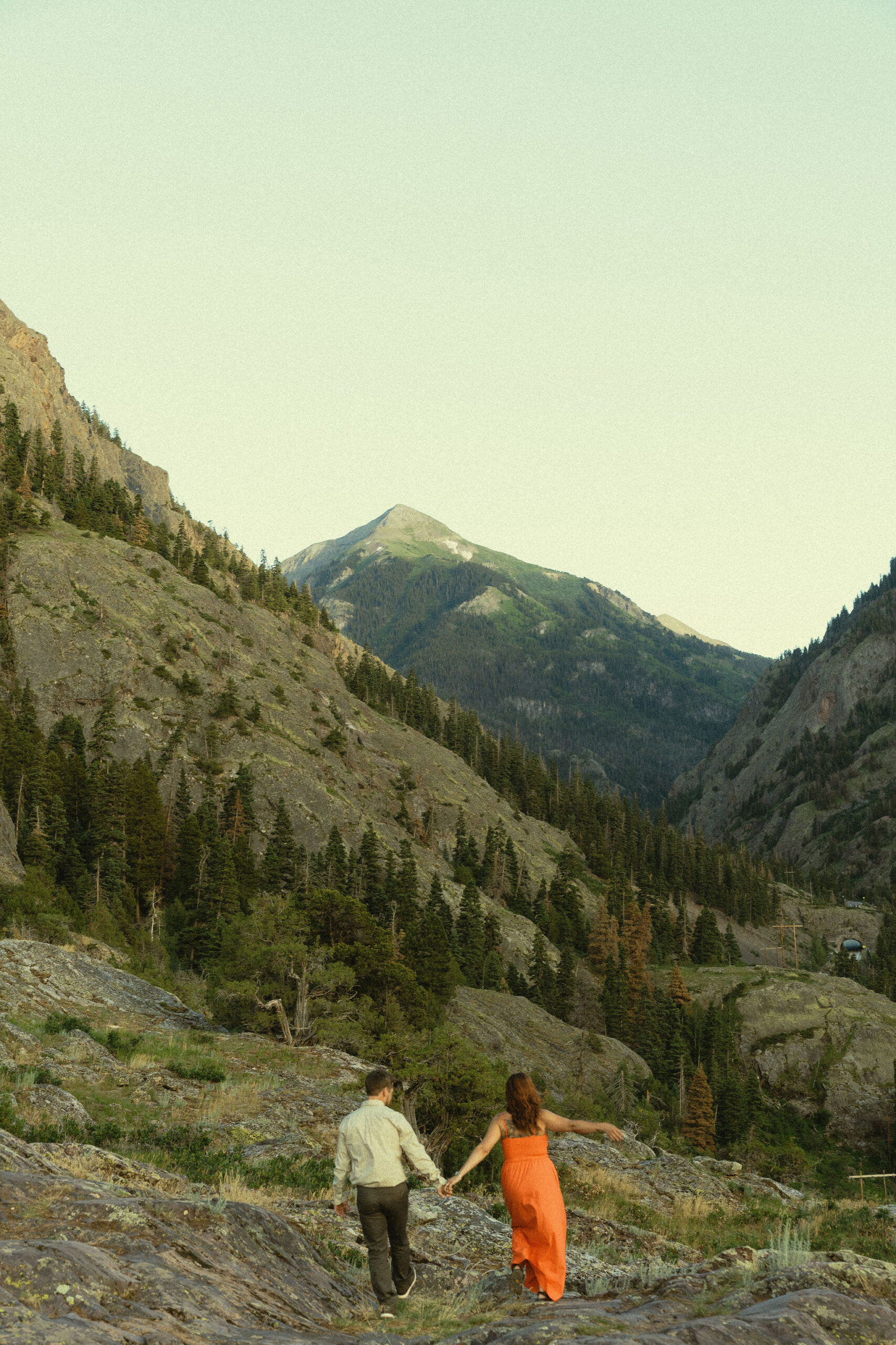 beautiful couple pose during their Ouray engagement photos with the Rocky mountains outside Ouray, Colorado