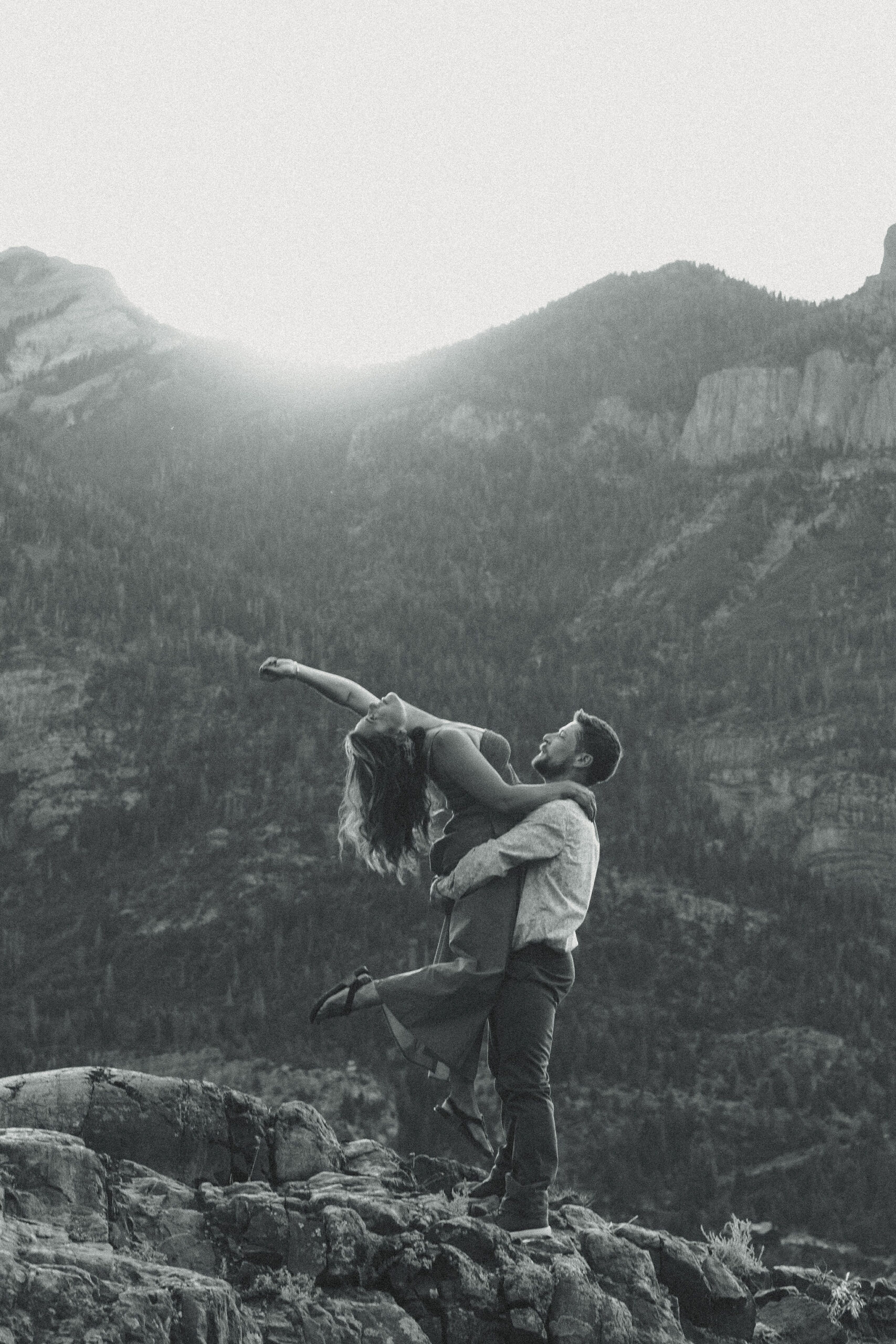 beautiful couple pose during their Ouray engagement photos with the Rocky mountains outside Ouray, Colorado