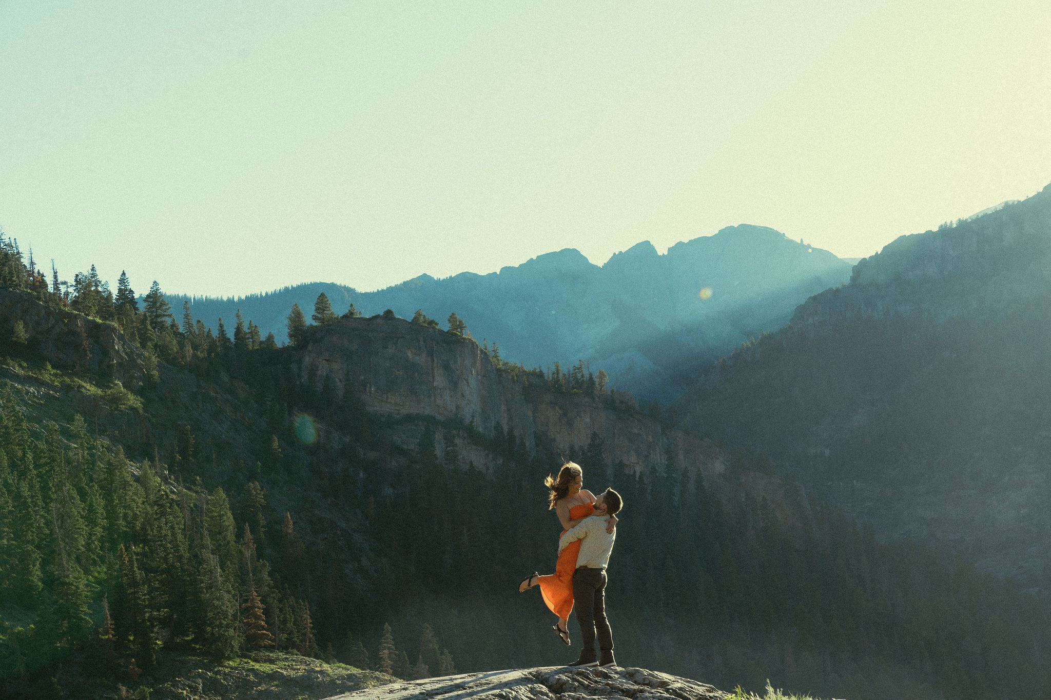 beautiful couple pose during their Ouray engagement photos with the Rocky mountains outside Ouray, Colorado