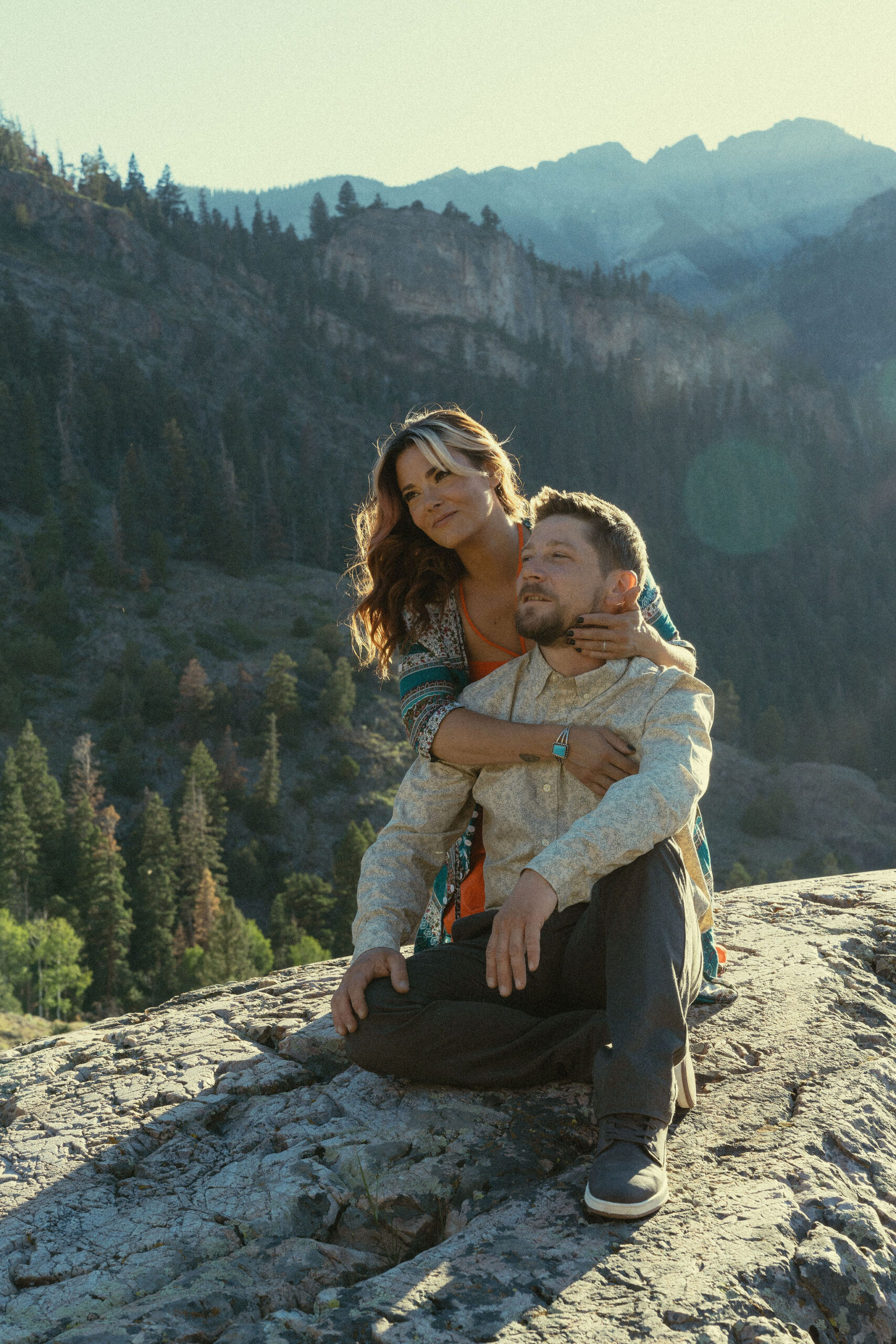 beautiful couple pose during their Ouray engagement photos with the Rocky mountains outside Ouray, Colorado