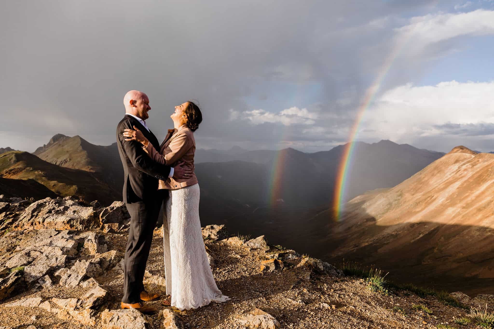 bride and groom pose with the Rocky Mountains behind them