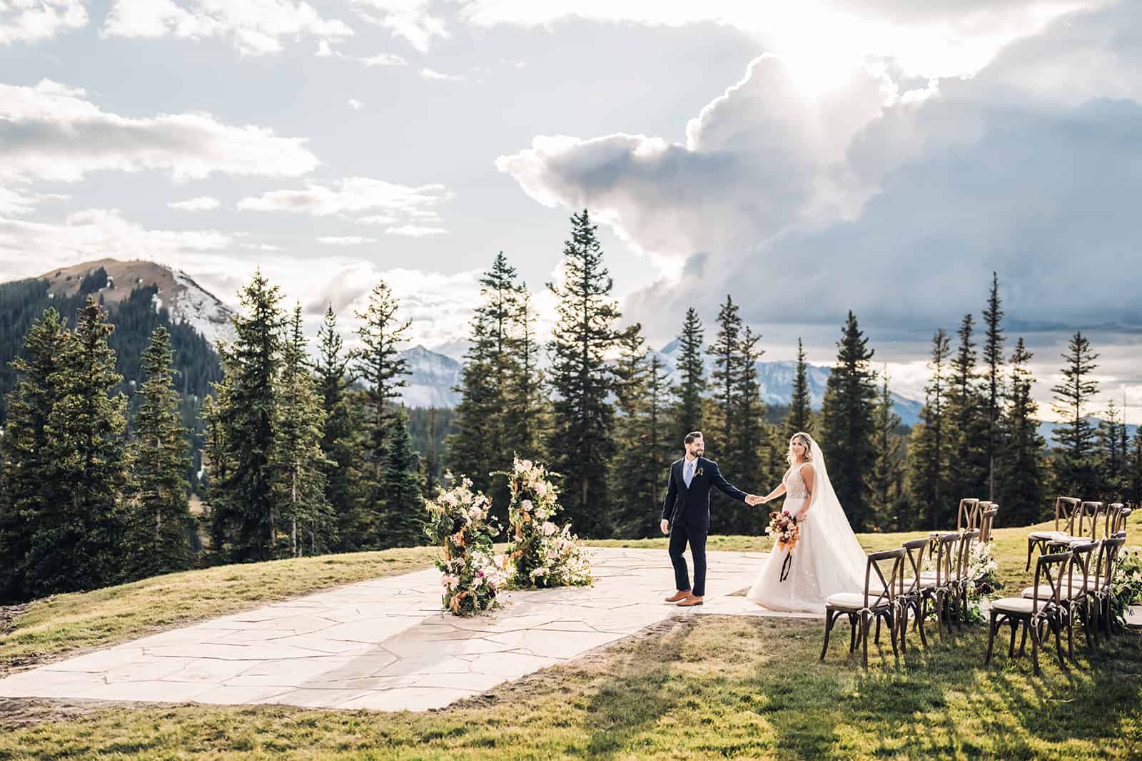 bride and groom pose with the Rocky Mountains behind them