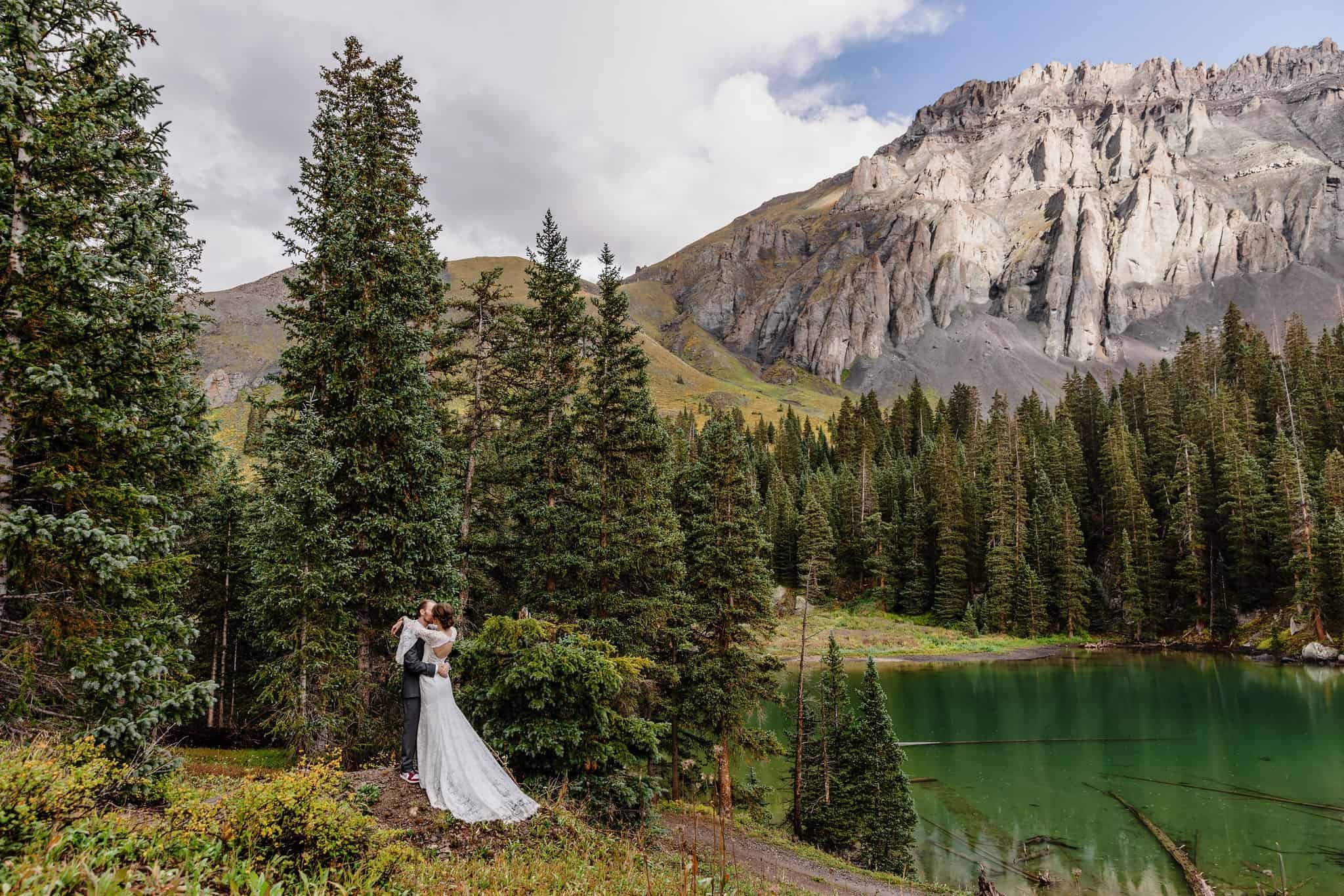 bride and groom pose with the Rocky Mountains behind them