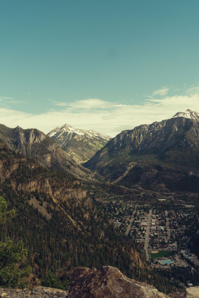 beautiful Colorado mountain range with a town peeking out at the bottom of valley