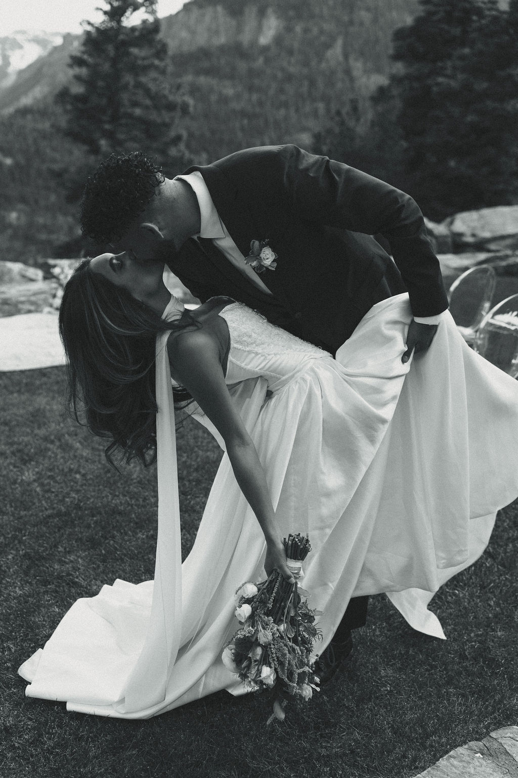 beautiful bride and groom share a kiss with the mountains stretching behind them at Gold Mountain Ranch In Colorado