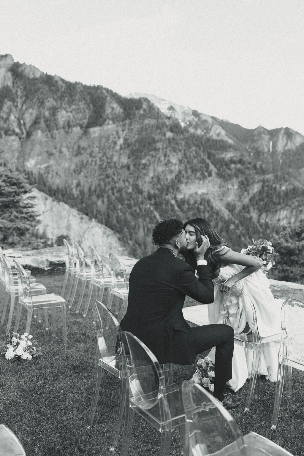 beautiful bride and groom share a kiss with the mountains stretching behind them at Gold Mountain Ranch In Colorado