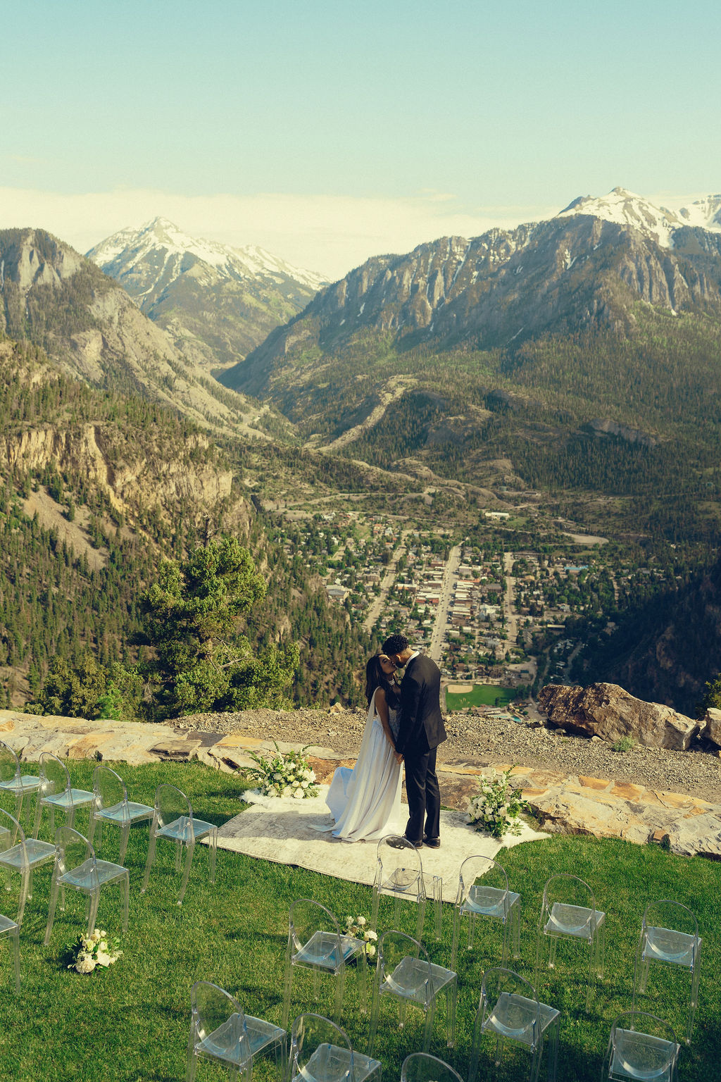 beautiful bride and groom share a kiss with the mountains stretching behind them at Gold Mountain Ranch In Colorado