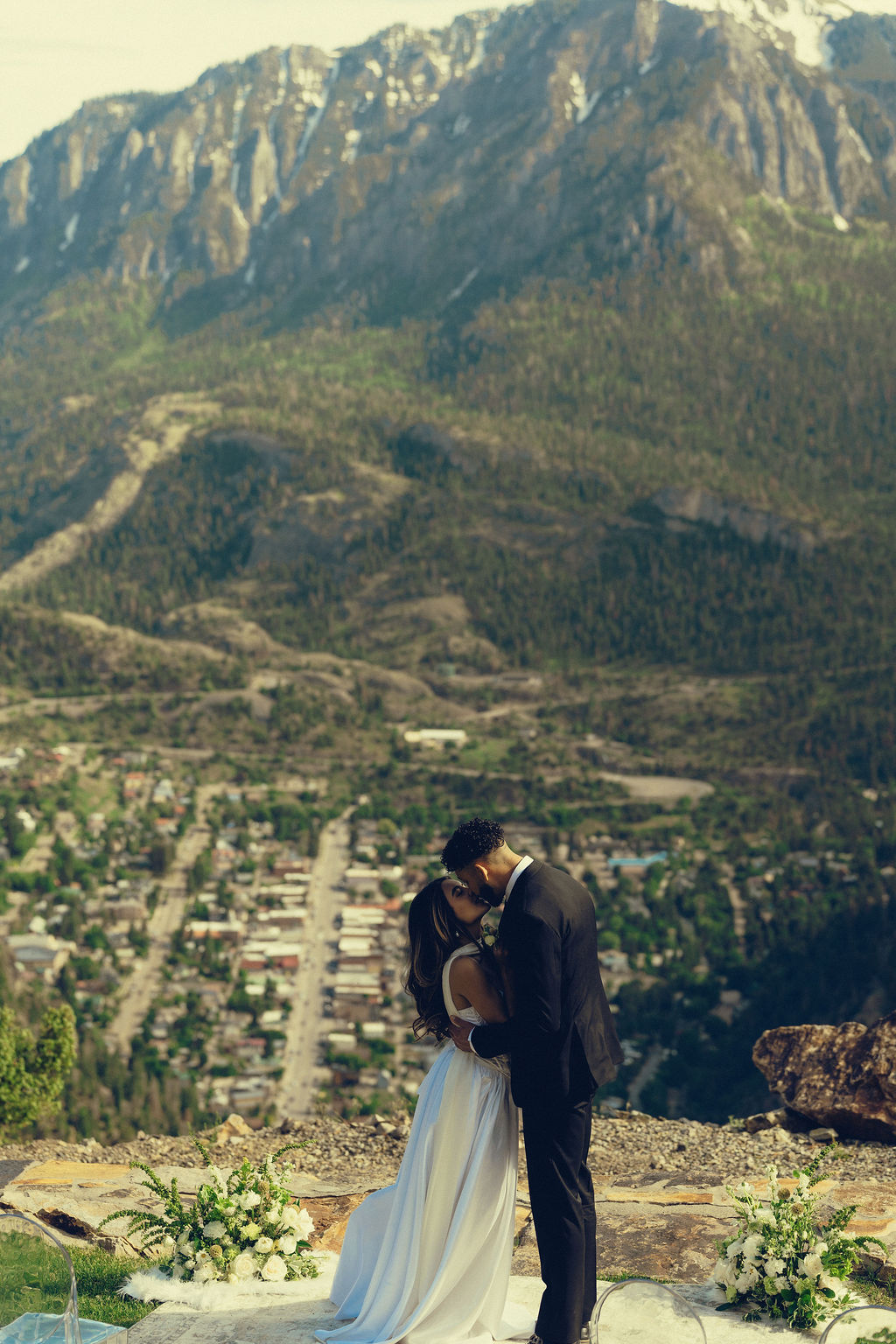 beautiful bride and groom share a kiss with the mountains stretching behind them at Gold Mountain Ranch In Colorado