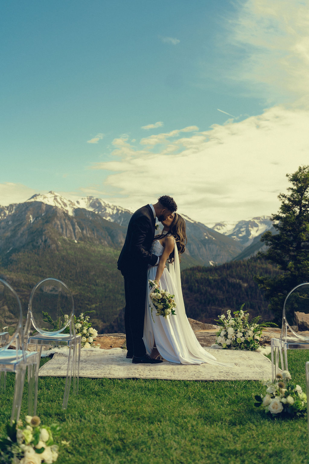 beautiful bride and groom share a kiss with the mountains stretching behind them at Gold Mountain Ranch In Colorado