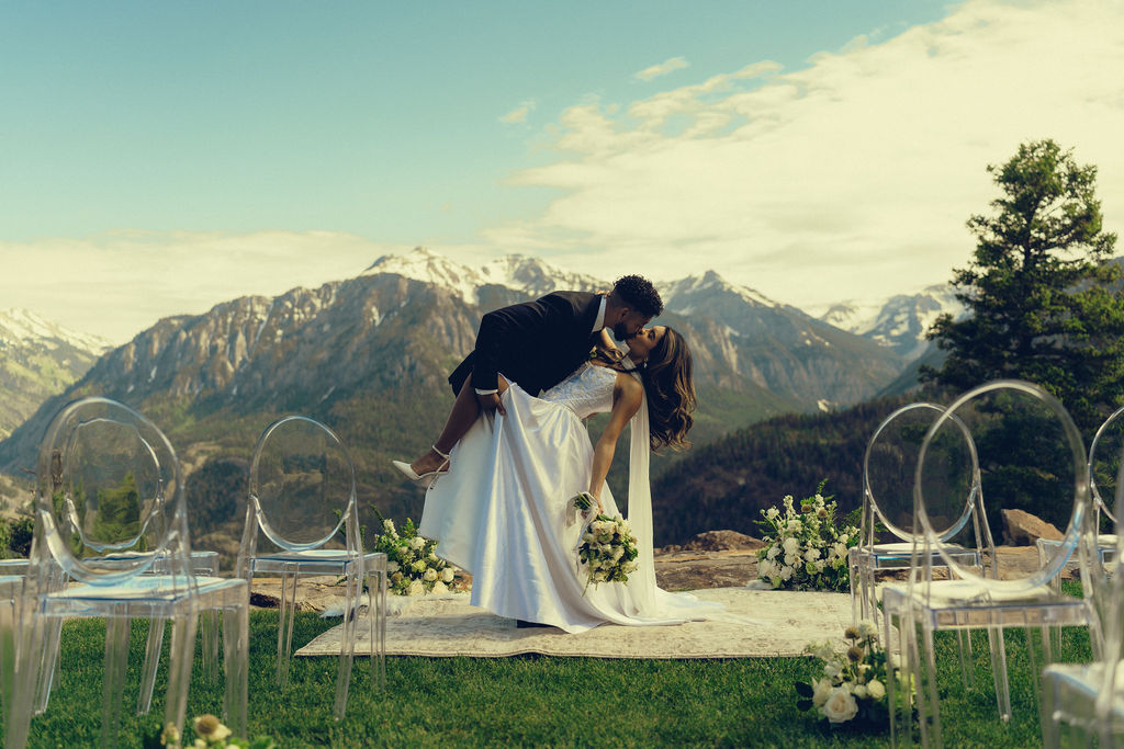 beautiful bride and groom share a kiss with the mountains stretching behind them at Gold Mountain Ranch In Colorado