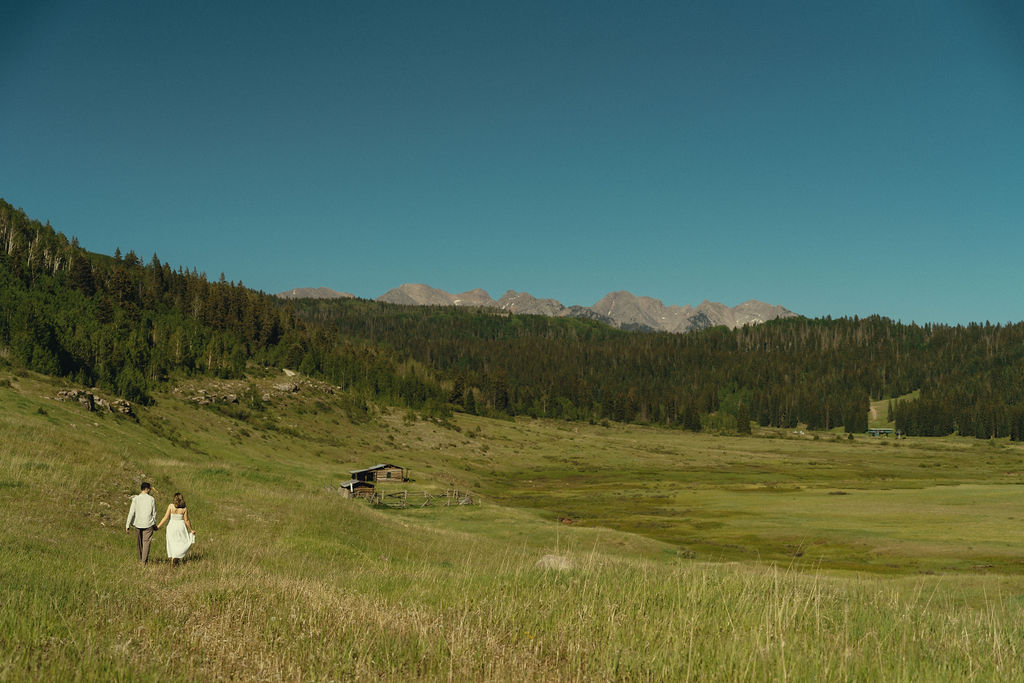 couple walk through a Colorado field together