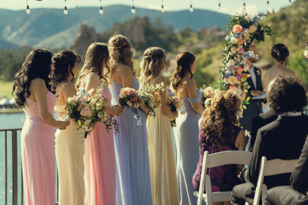 pastel bridesmaids watch as the ceremony takes place