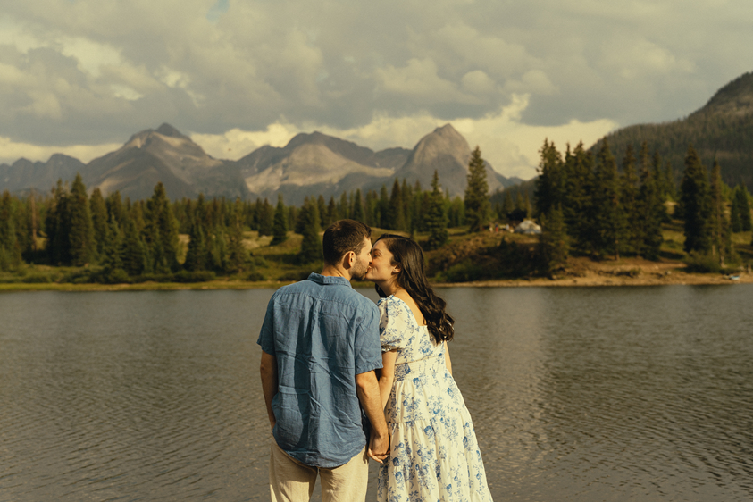 beautiful couple share a kiss by Molas Lake during their engagement session