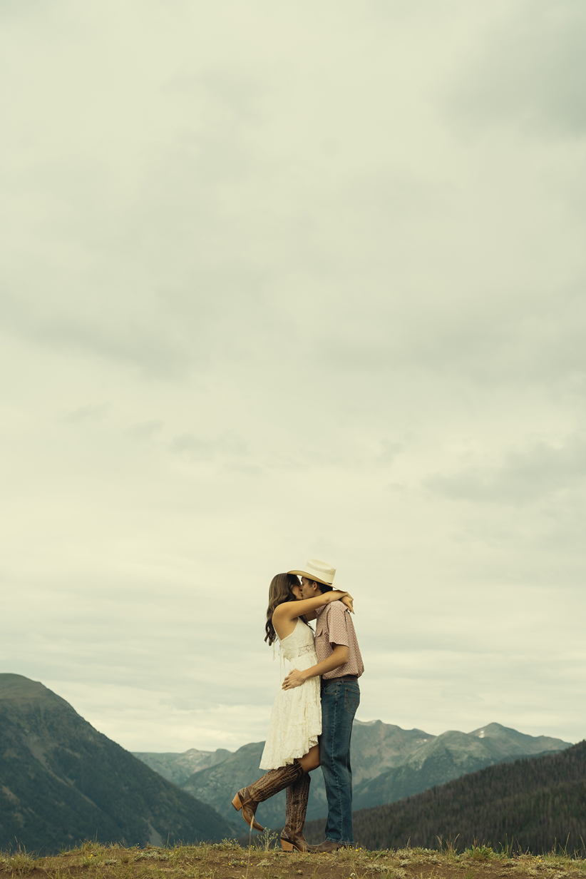 beautiful couple share a kiss during their mountain engagement photos with Sasha Takes Pictures