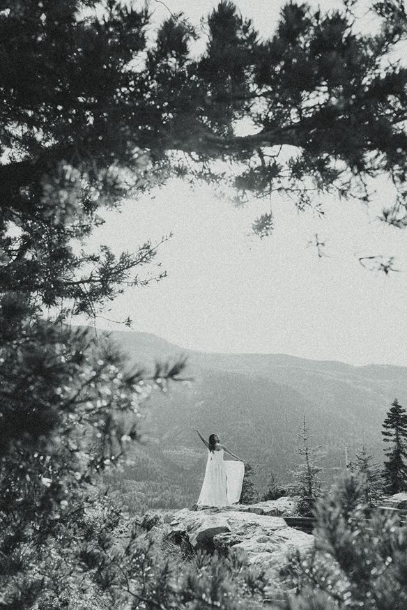bride poses on a rock in the san juan mountains
