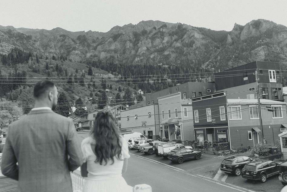 bride and groom look over the town nestled between the peaks