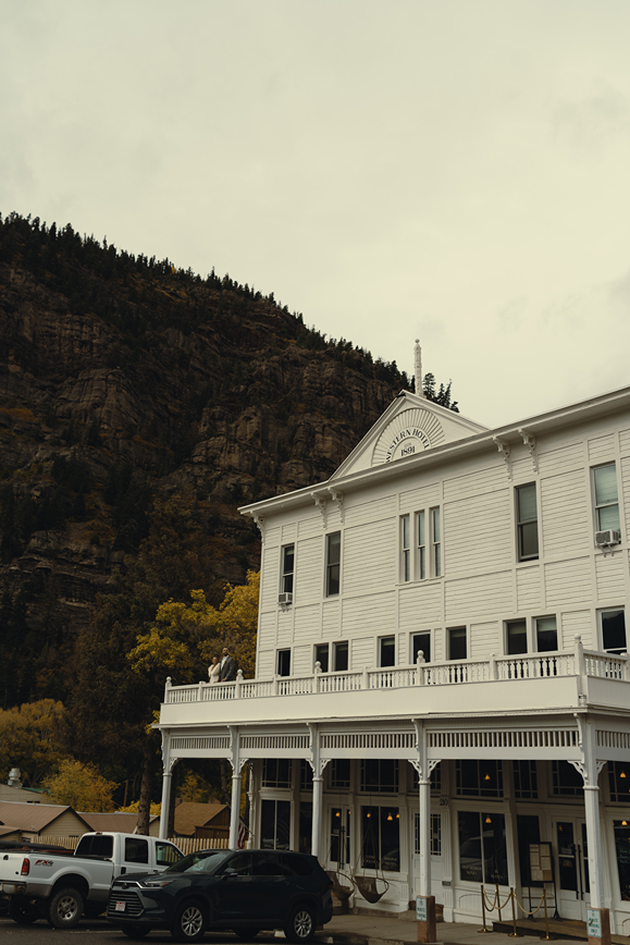 beautiful bride and groom stand on the western hotel balcony after their Colorado wedding day