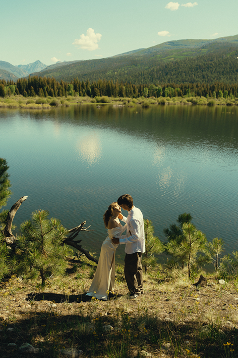 bride and groom share a kiss by the lakeside during therir