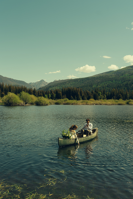 bride and groom ride in the canoe together during their Colorado elopement