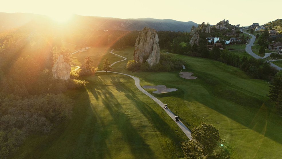 golf carts drive towards the sunset 