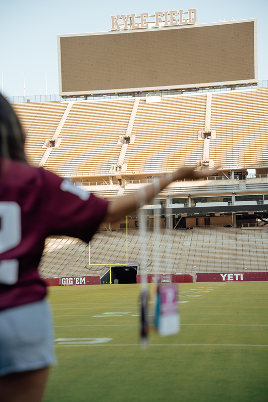 girl poses in her 12th man jersey in Kyle Field during her texas a&m graduation photos