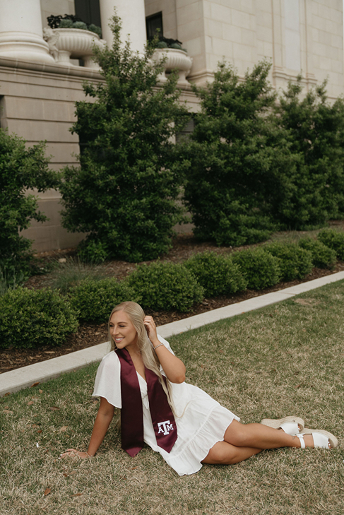 senior poses with her cap and gown during her on campus photoshoot