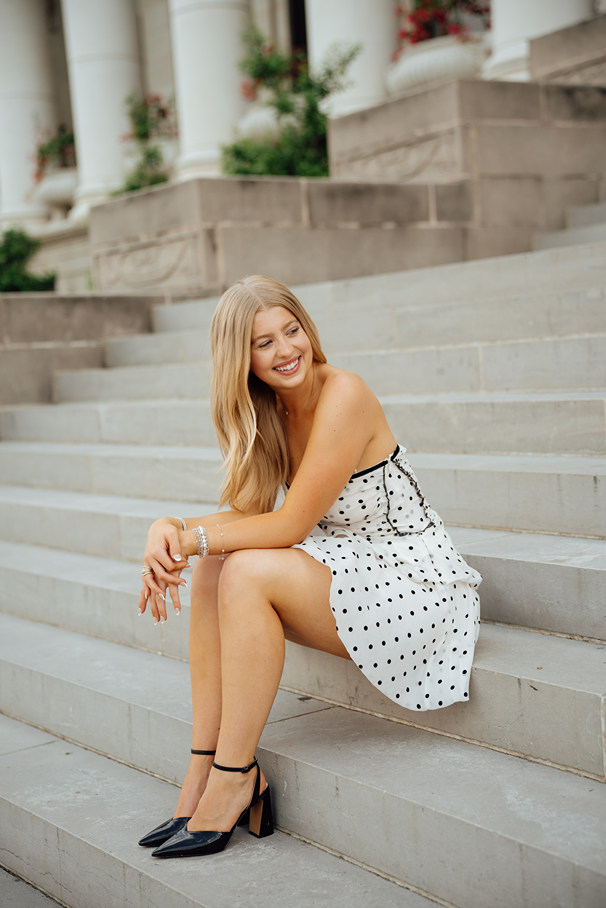 senior poses on the stairs during her on campus photos