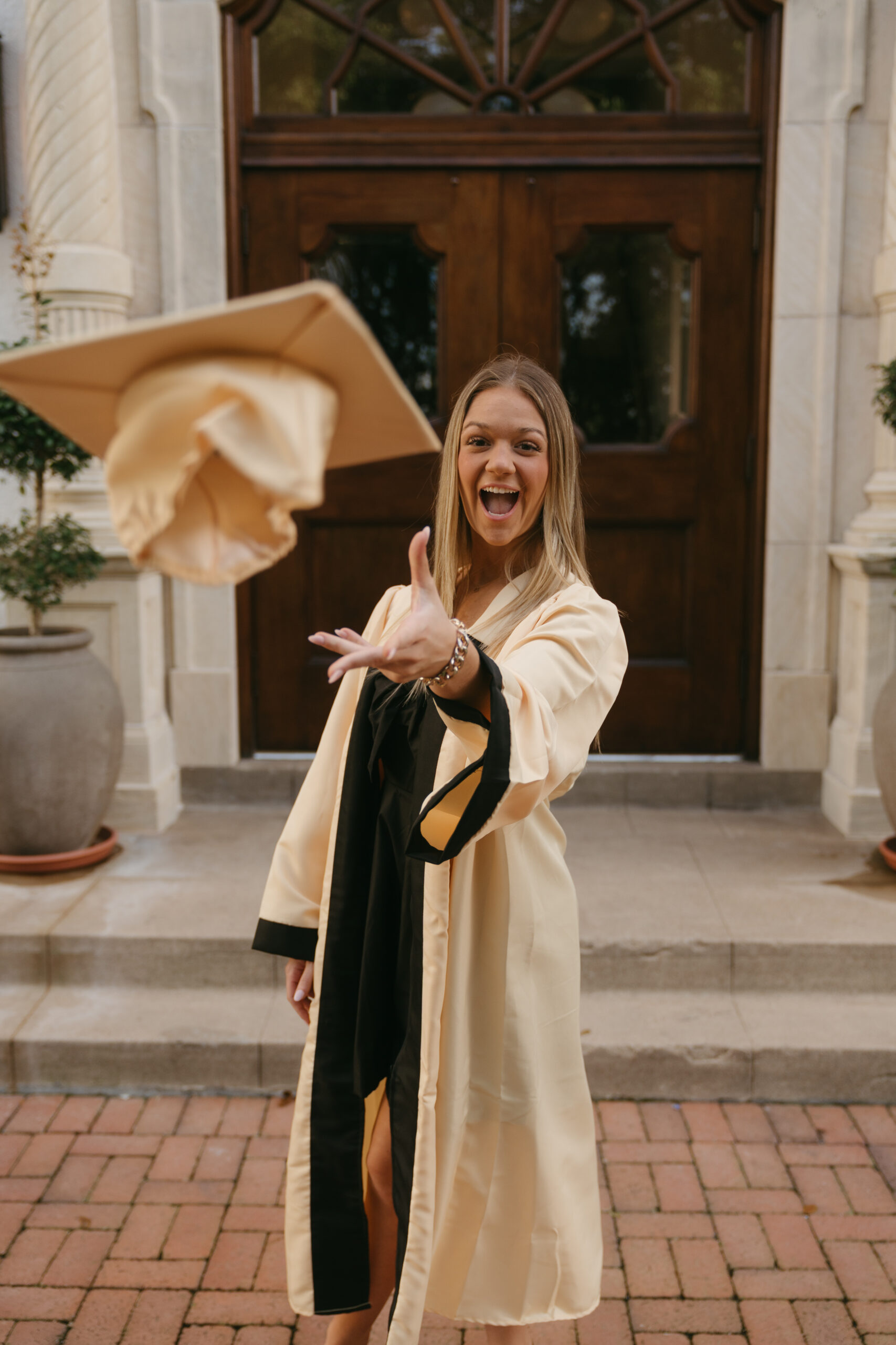 houston senior throws tosses her graduation cap towards Sasha as she snaps a photo