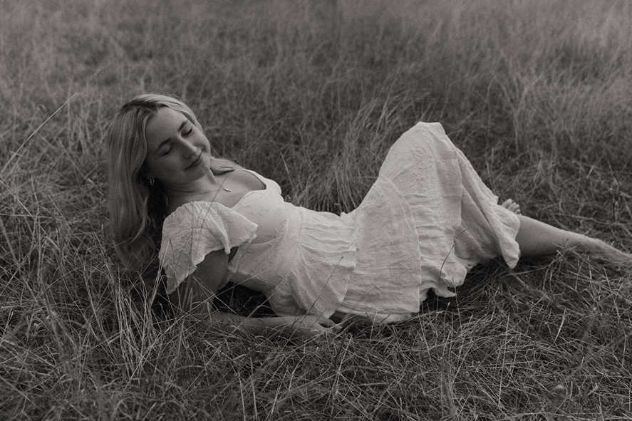 houston senior lies in a Texas field during her photoshoot with Sasha