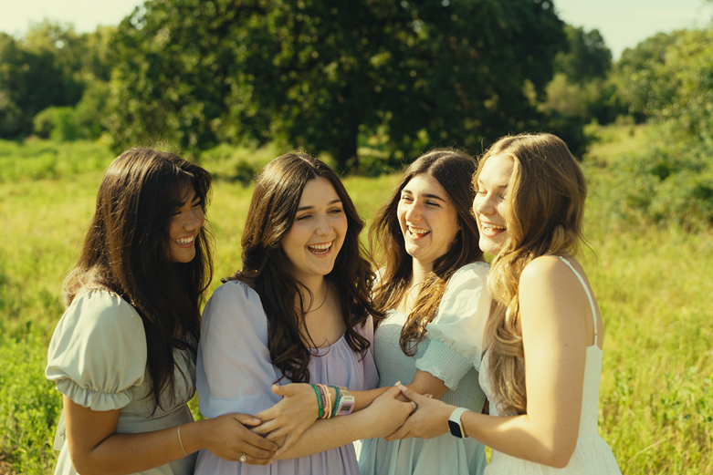 group of girlfriends hug and share a laugh during their college station senior photo session