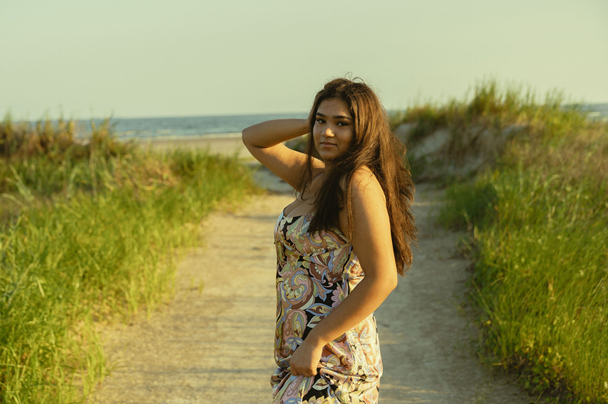 senior poses on the Texas beach during her galveston senior pictures